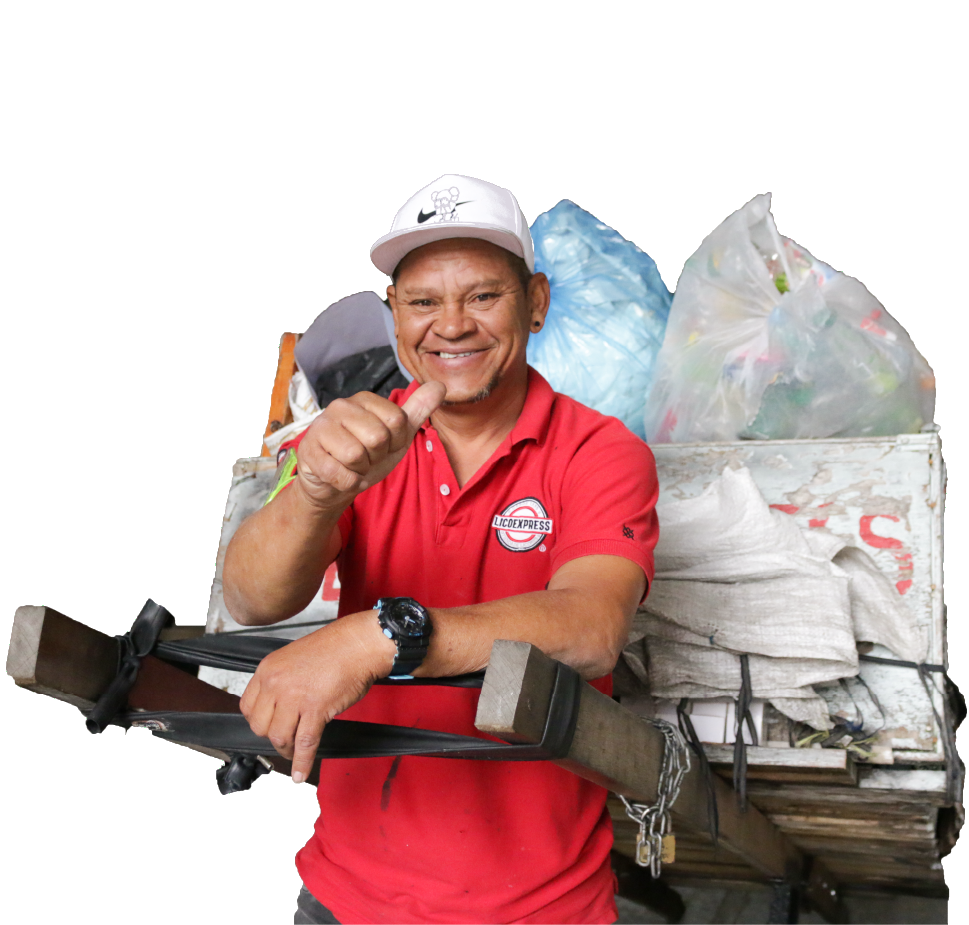 Carretero - reciclador que viste camiseta roja lleva su carreta a cuestas con residuos aprovechables.