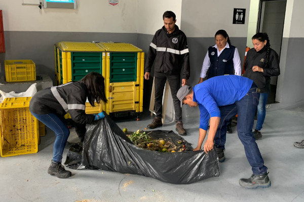  Dos personas recogen los residuos orgánicos para depositarlos en las composteras entregadas por la UAESP en colegios, universidades y centros comerciales.