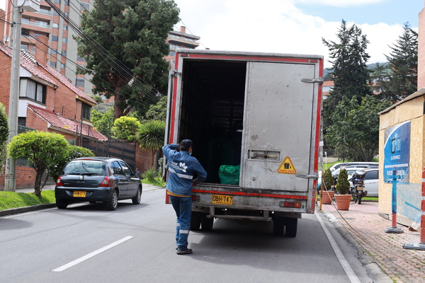 Señor de la ruta de recolección subiendose al camión luego de recoger los residuos orgánicos.