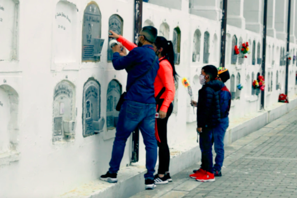 Una familia en el Cementerio Distrital Central coloca arreglos florares en uno de los osarios.