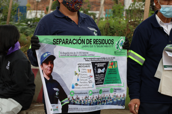 Recicladores que participaron de la jornada exhiben un cartel con información para la ciudadanía.
