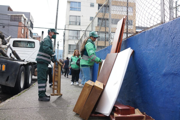 Operario y gestora social disponiendo madera en el Ecopunto.