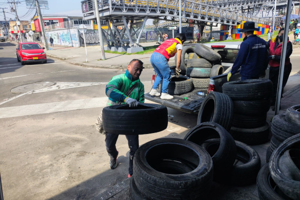 Colaborador recogiendo llantas fuera de uso.