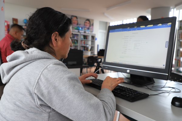 Mujer cabeza hogar trabaja al frente de un computador en el Nodo Digital de la Manzana del Cuidado.