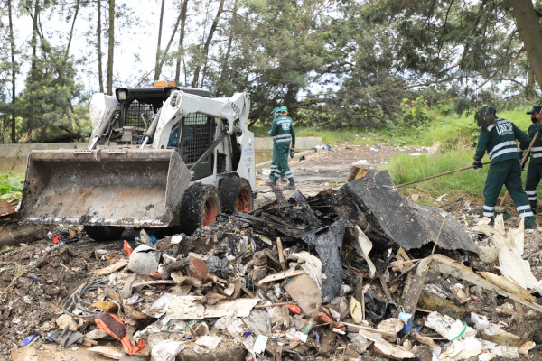 Operarios de aseo recuperan y limpian una calle que se había convertido en un botadero de basura.