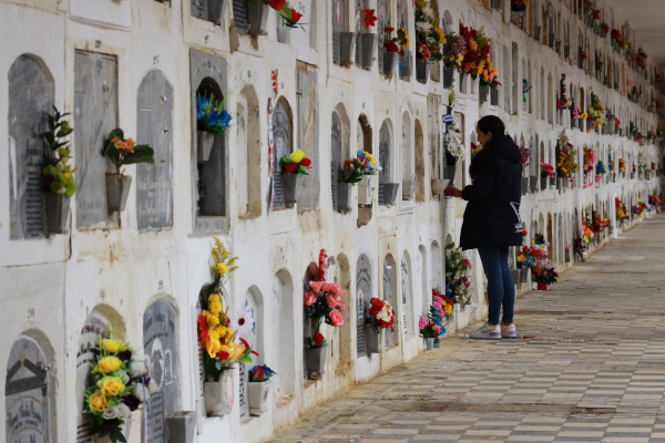 Imagen de una usuaria en uno de los mausoleos  del Cementerio Distrital Central. La mujer visita los restos de su ser querido fallecido que reposan en el lugar.