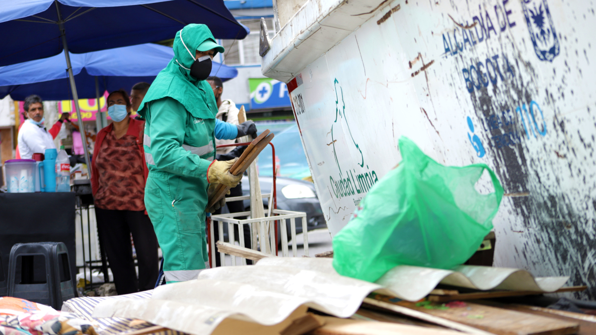 Operario de aseo acomoda residuos dejados por los ciudadanos en un Ecopunto.