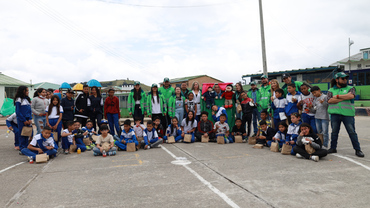 Niños, niñas, funcionarios y funcionarias de la UAESP posando en media Luna en la cancha del colegio, para la foto final de la actividad.