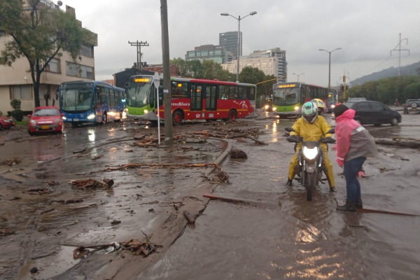 Trabajadores de Promoambiental limpian las calles llenas de lodo y madera.