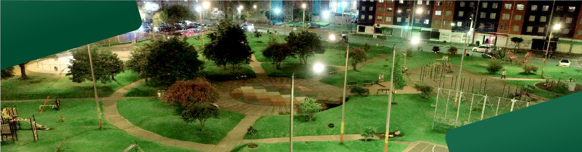 En la imagen: Un registro aéreo nocturno tomado con un dron, el cual nos muestra un gran parque con sus zonas verdes, zonas de juego y canchas múltiples iluminadas con luz blanca.