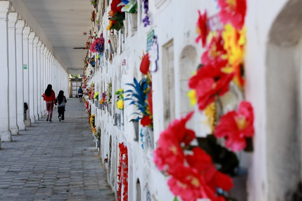 Una mujer y una niña caminan por el pasillo de uno de los mausoleos del Cementerio Distrital Central. Llevan consigo flores para dejarlas en la tumba donde reposan los restos de su ser querido.