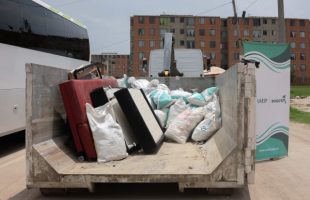 Ecopunto con muebles viejos y escombros.