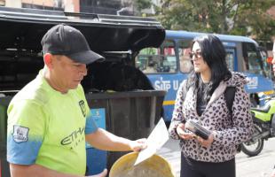 Gestora de la UAESP explican a un ciudadano la importancia de respetar los horarios de recolección de basura.