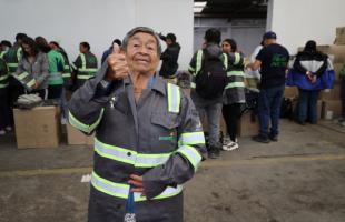 Foto en el exterior de una bodega luciendo el uniforme que ha sido entregado.