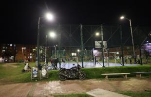 Un grupo de jóvenes practican fútbol en la cancha múltiple del Parque Miami, tras la modernización del alumbrado público.