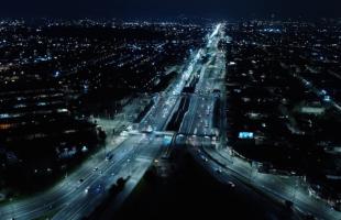Imagen aérea nocturna de la Avenida de las Américas con Carrera 78K. En esta fotografía se muestra la Estación Banderas de TransMilenio tras el mejoramiento del alumbrado público. 