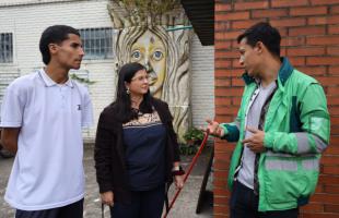 Estudiante y docente dialogan con un profesional de la Uaesp