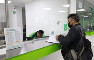 Imagen de Héctor Julio Arévalo, revisando documentos frente a la ventanilla de subvenciones funerarias en la sede principal de la UAESP, ubicada en la Avenida Caracas # 53-80.