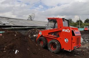 Bobcat haciendo volteo de material orgánico durante el proceso.