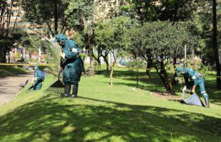 Operarios de la UAESP recogiendo césped, para entrega óptima de espacio público, luego de corte.