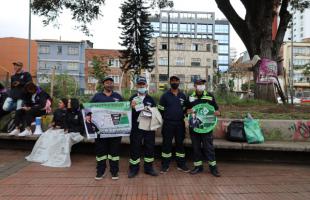 Reciclador exhibe cartel con datos sobre la correcta separación de residuos.