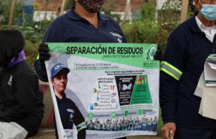 Recicladores que participaron de la jornada exhiben un cartel con información para la ciudadanía.