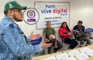 Funcionario de la UAESP se dirige al auditorio. Dos hombres y una mujer lo escuchan atentamente.