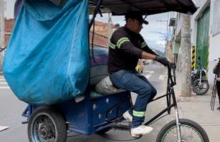 Reciclador montando su triciclo