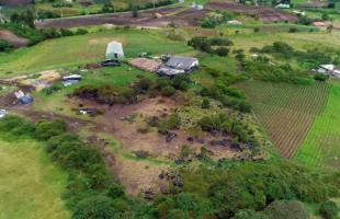 En la foto se aprecia desde el aire cómo están tiradas las llantas abandonadas sobre el terreno rural, varias de ellas cubiertas por pasto y árboles.