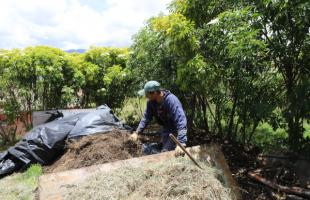 Persona realiza tareas de compostaje en el Predio Los Manzanos.