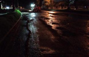 Durante la noche, máquina de trabajo realiza labores de limpieza y mantenimiento en vía encharcada.
