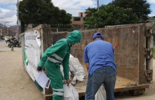 Operario y ciudadano ingresan residuos de construcción dentro de caja estacionaria de Ecopunto.