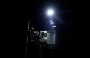 Imagen de un operario de alumbrado público en una canasta frente a una luminaria realizando labores de mantenimiento.