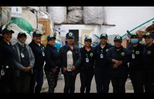 Foto 3/4 de mujeres posando para la foto. Las mujeres están vestidas de azul oscuro con gorra, debidamente identificadas que pertenecen a una organización de recicladores.
