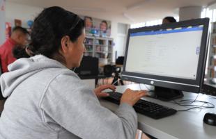 Mujer cabeza hogar trabaja al frente de un computador en el Nodo Digital de la Manzana del Cuidado.