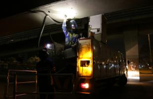 Operarios de Enel Colombia intervienen una de las luminarias vandalizadas por delincuentes bajo el puente vehicular de la Calle 26 con Avenida Boyacá.