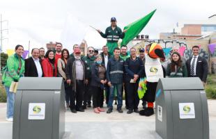 Miembros de la UAESP y Promoambiental posan junto a la comunidad beneficiada con el contenedor soterrado.