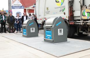 Camión de basura atiende el contenedor recién instalado.