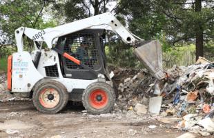 Operarios de aseo recuperan y limpian una calle que se había convertido en un botadero de basura.