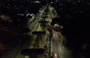 Vista aérea nocturna del corredor de la avenida Caracas, donde se observan las obras del tramo 5 de la Línea 1 del Metro de Bogotá y la operación de TransMilenio.