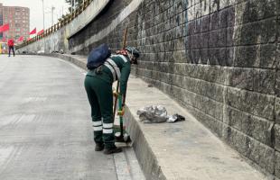 Operaria terminando de limpiar la calle.
