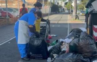 Trabajadores de la IPS recogiendo sus residuos de la calle.