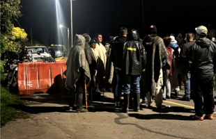 Un grupo de habitantes de los Mochuelos reunidos en la noche.