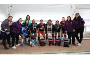 Las mujeres que jugaron el torneo de microfútbol lucen sus medallas, cactus, libros y anchetas.