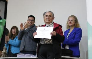 Mujer recicladora de oficio recibe diploma que la certifica en competencias laborales relacionadas con separación de residuos, otrogado por el Servicio Nacional de Aprendizaje SENA.