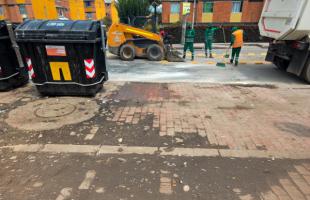 Operarios realizando limpieza alrededor de contenedores.