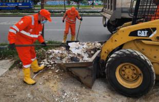 Operarios de Aguas de Bogotá recogiendo residuos especiales abandonados en el espacio público.