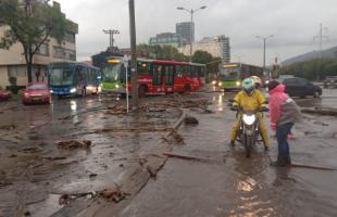 Trabajadores de Promoambiental limpian las calles llenas de lodo y madera.