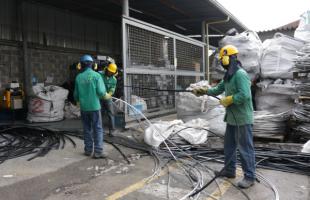 Operarios realizan proceso de separación de metal y plástico del cableado que sale o cumple su vida útil en el sistema de alumbrado público de Bogotá.